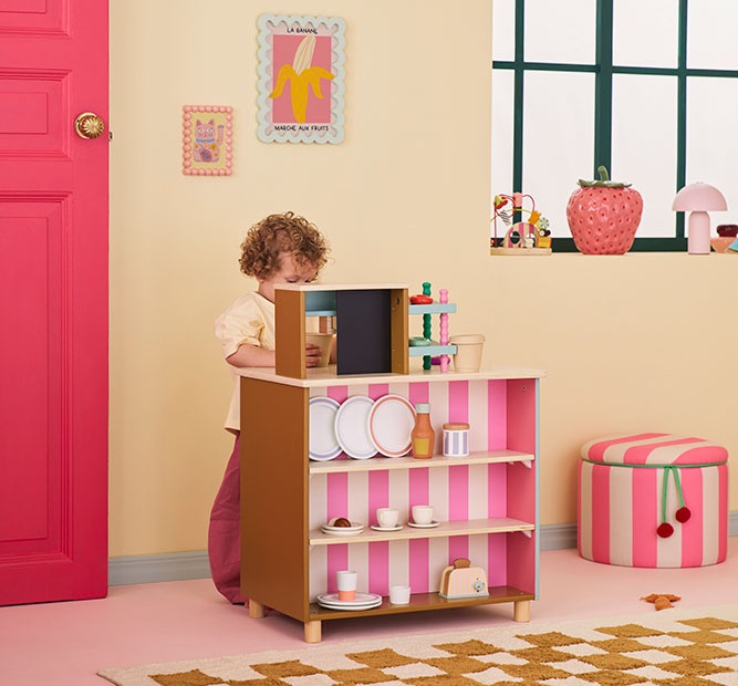 Dziecko bawiące się drewnianą kawiarnią Kid's Concept w pokoju dziecięcym