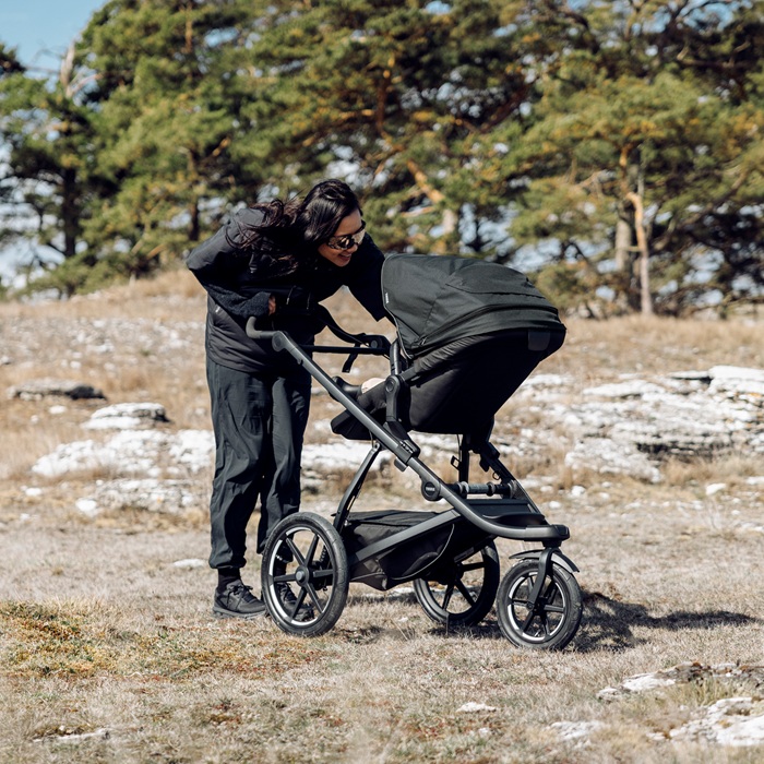 Thule Urban Glide reversible seat z rozłożonym daszkiem chroniącym dziecko przed wiatrem i słońcem