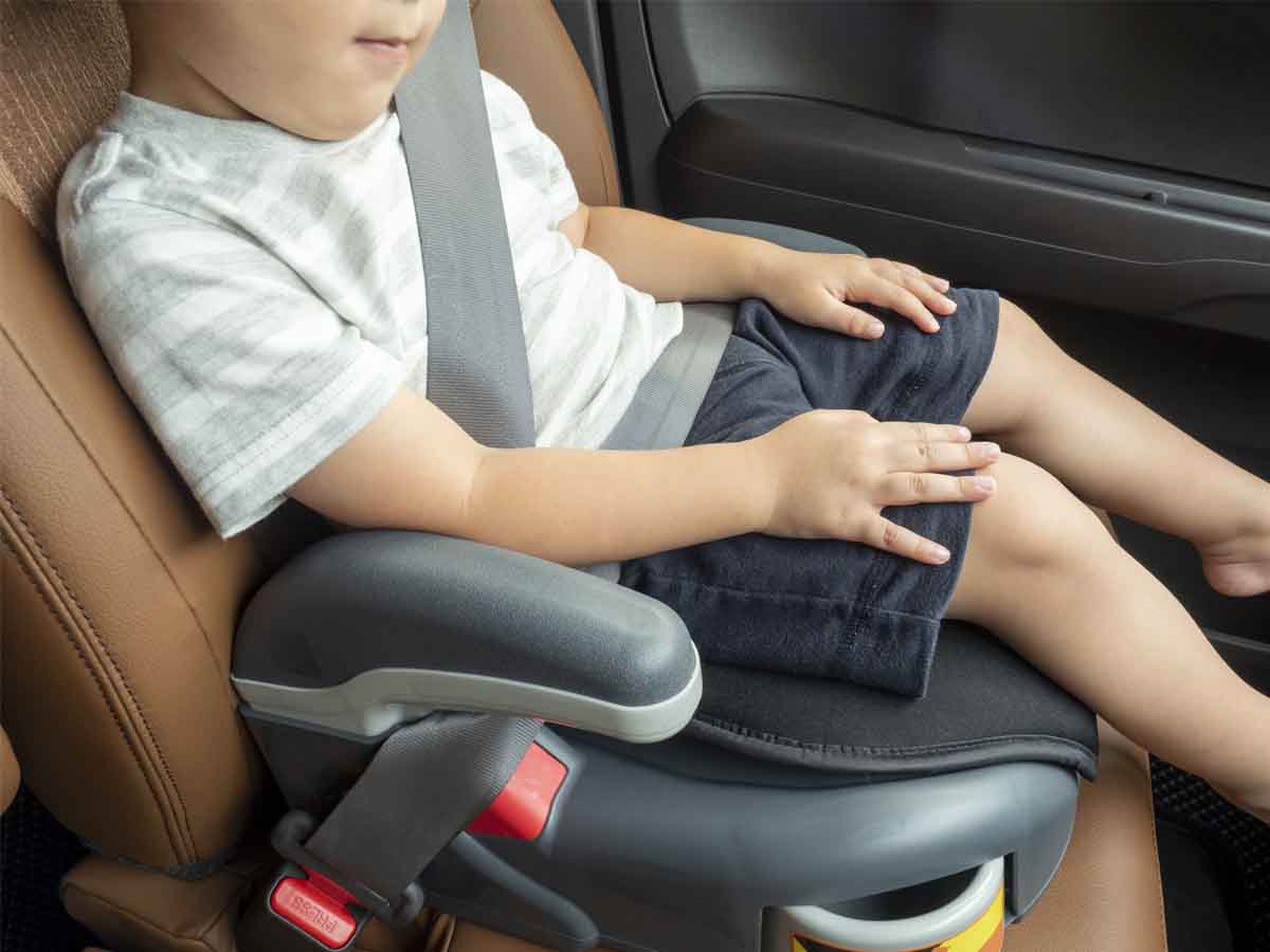 Dziecko jedzie na podstawce w samochodzie zamiast fotelika.